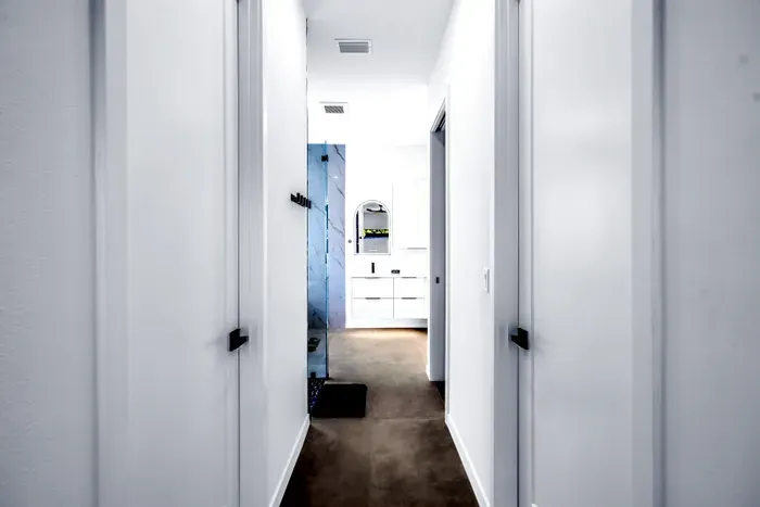 Bright modern hallway leading to a sleek spa-style bathroom