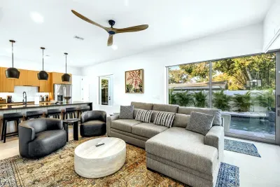 Bright open living space with modern kitchen and poolside views