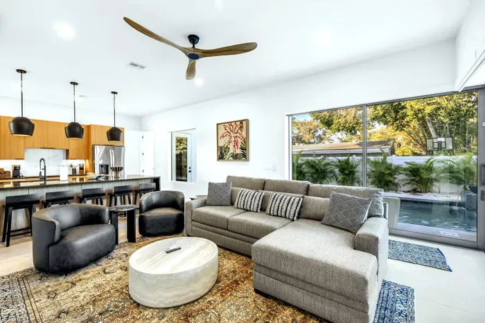 Bright open living space with modern kitchen and poolside views