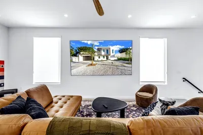 Bright modern lounge with leather sofas and oversized wall-mounted TV