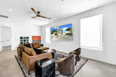 Bright modern living room with oversized TV and stylish lounge seating