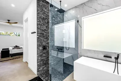 Spa-style bath with soaking tub, glass shower, and luxe modern finishes