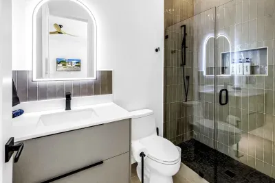 Modern spa-style bathroom with glass walk-in shower and lit mirror