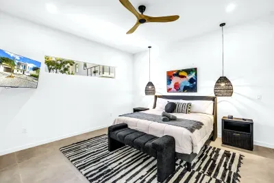 Bright modern king bedroom with high ceilings and stylish decor