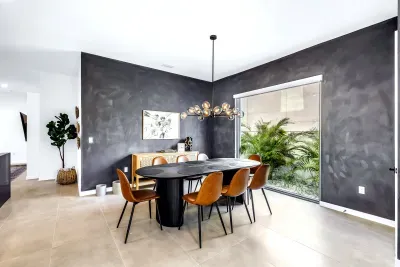 Modern dining room with statement lighting and serene garden-view window