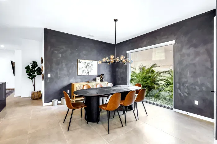 Modern dining room with statement lighting and serene garden-view window