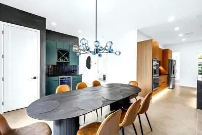 Designer dining space with statement lighting, bar nook, and sleek modern kitchen