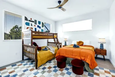 Bright family bedroom with queen bed, bunk beds, and modern design