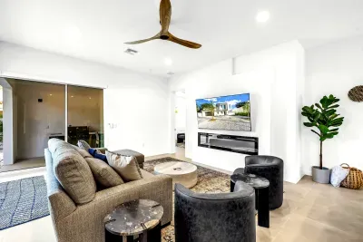 Bright modern lounge with patio access, large TV, and stylish seating