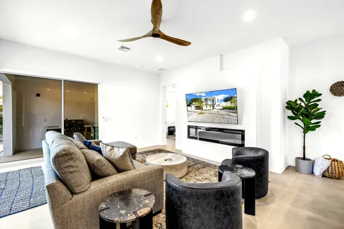 Bright modern lounge with patio access, large TV, and stylish seating