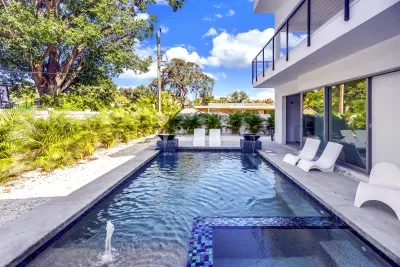 Modern private pool with sun shelf, loungers, and lush tropical surrounds
