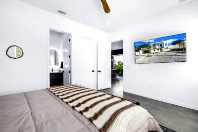 Bright modern bedroom with ensuite bath and wall-mounted TV
