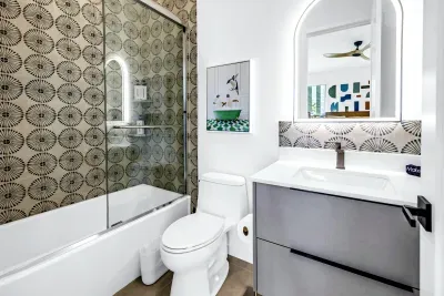 Stylish modern bath with bold tile, tub-shower combo, and sleek vanity