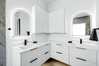 Modern double vanity with backlit mirrors and sleek spa-like design