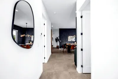 Bright modern entryway with designer mirror and stylish dining view