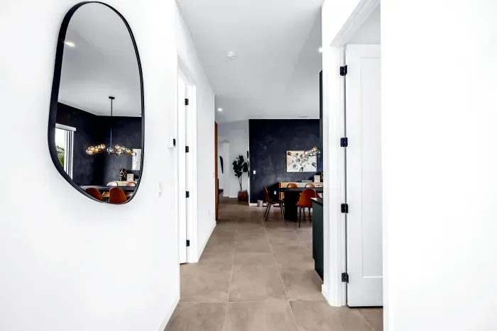 Bright modern entryway with designer mirror and stylish dining view