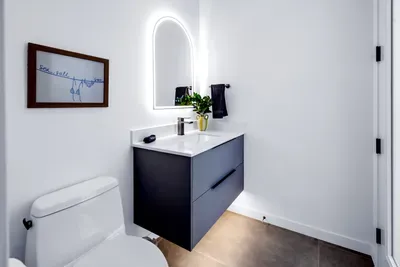 Bright modern bathroom with floating vanity and elegant backlit mirror