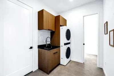 Modern laundry room with stacked washer/dryer and stylish utility sink