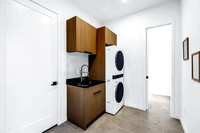 Modern laundry room with stacked washer/dryer and stylish utility sink