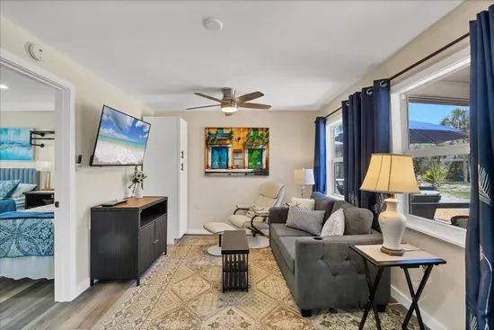 Sunny living room with plush seating, smart TV & patio views