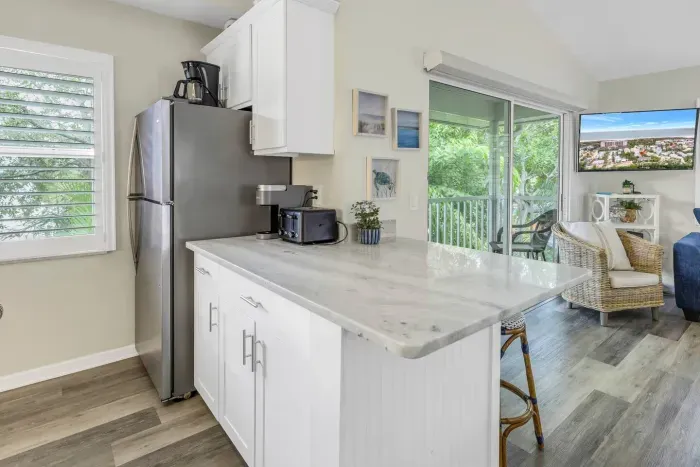 Kitchen: Bright space with modern appliances and a charming balcony view to savor morning coffee!