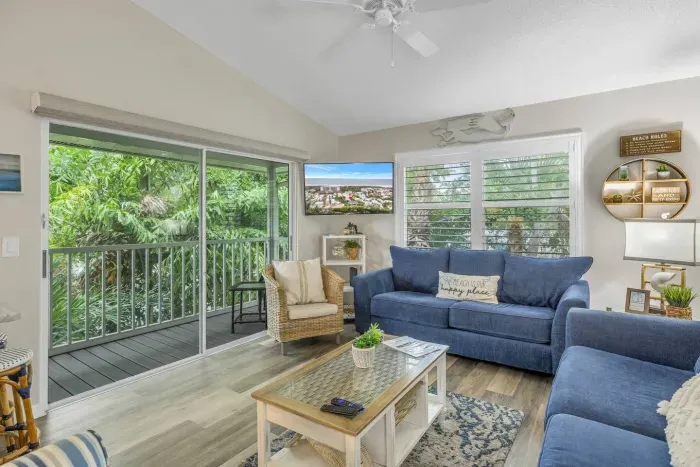 Living Room Retreat: Bright, airy space with lush views, comfy seating, and beachy decor await you!