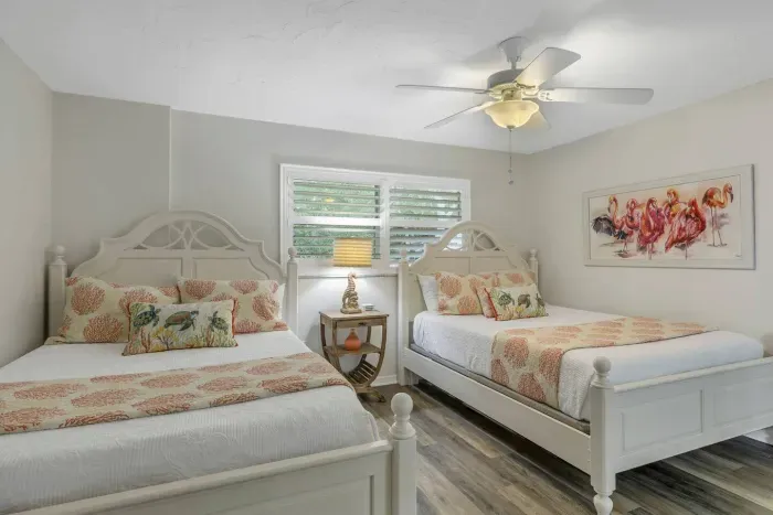 Charming Guest Room: Bright space with two queen beds, coastal decor, and a lovely view of greenery!