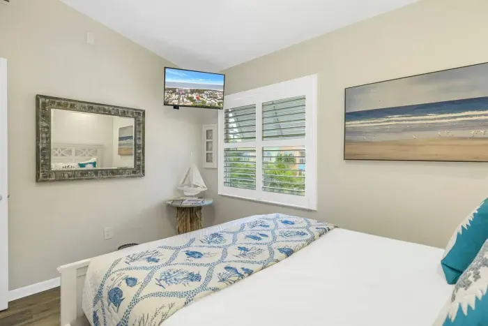Bedroom: Bright and airy retreat with beachy decor and stunning views through plantation shutters!