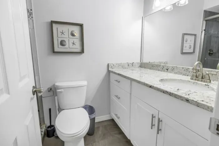 Charming Bathroom: Relax in style with granite counters and beachy decor! Perfect for unwinding!