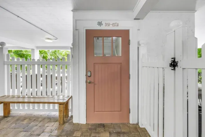 Entryway: Bright pink door welcomes you to your seaside getaway in lush Siesta Key!