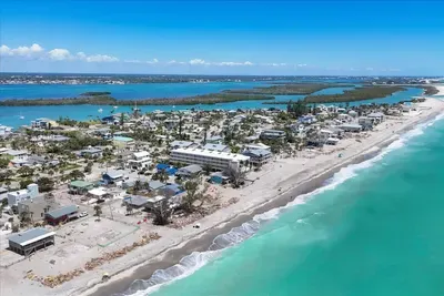 Beachfront barrier‑island stay with turquoise surf and bayside views.