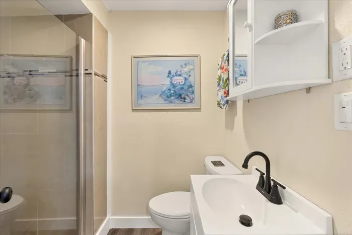 Bright bath with walk-in shower, modern vanity, and coastal touches.