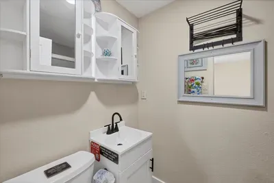 Bright, compact bath with ample storage, sleek vanity, and towel rack.