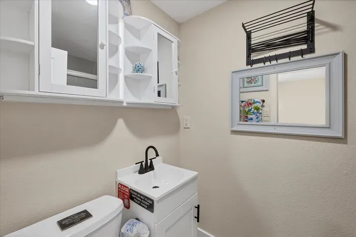 Bright, compact bath with ample storage, sleek vanity, and towel rack.