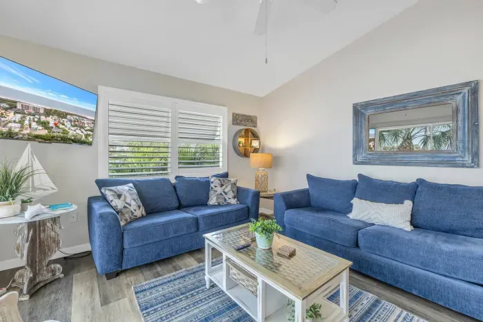 Living Room: Bright and airy space with plush seating and tropical views for relaxation and fun!