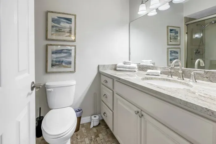 Bathroom Oasis: Elegant granite countertops and beach-inspired decor await your refreshing retreat!