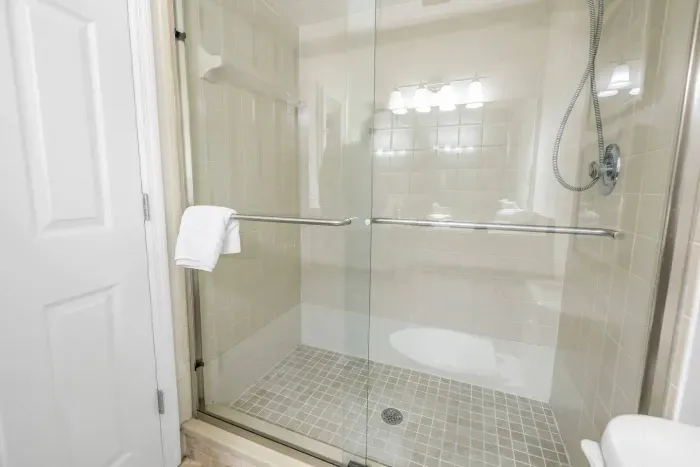 Spacious Shower Room: Refresh in style with modern glass features and soft, serene lighting!