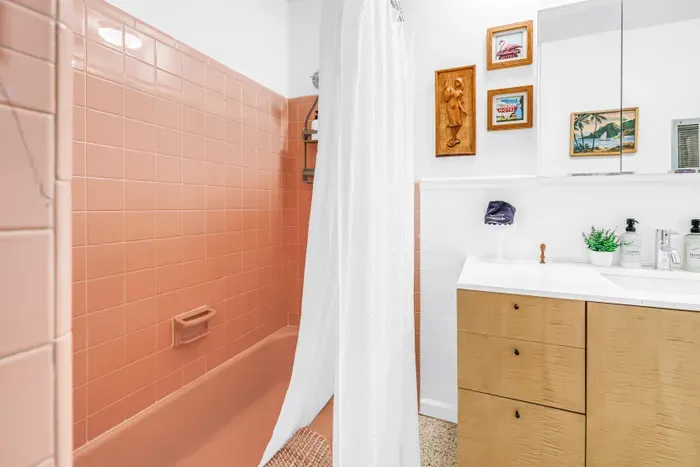 Charming retro bath with pink tile, bright vanity, and stylish vintage touches