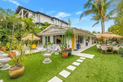 Tropical garden patio with lush lawn, stylish seating, and outdoor dining