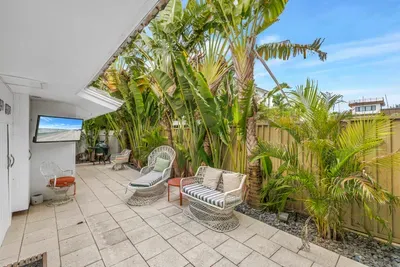 Private tropical patio with lounge seating and outdoor TV