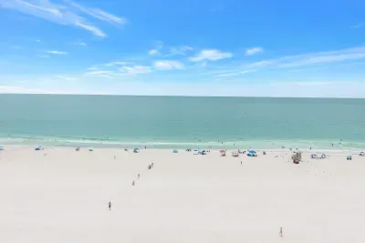 Expansive white-sand beach with calm turquoise water and open sky