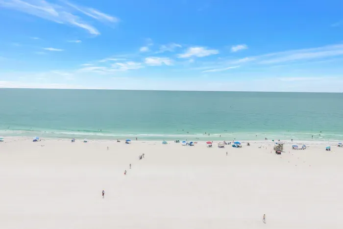 Expansive white-sand beach with calm turquoise water and open sky