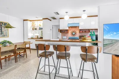 Bright open kitchen with breakfast bar, dining nook, and seating for four