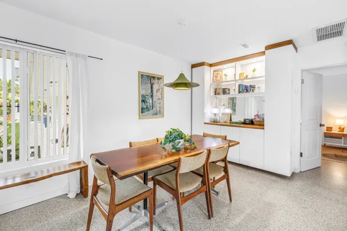 Bright dining space with seating for four and stylish built-in shelves