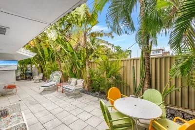 Private tropical patio with lounge chairs, dining area, and lush garden vibes