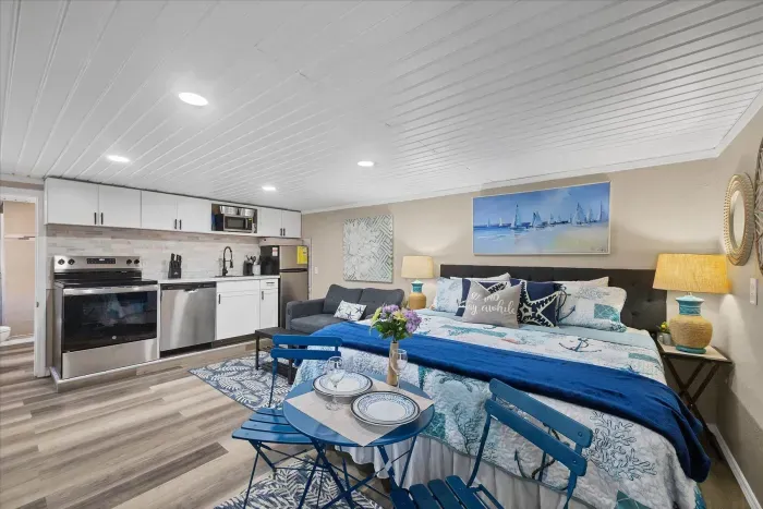Coastal-chic studio with king bed, full kitchenette, and cozy seating.
