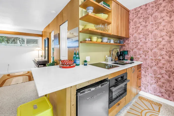 Bright retro-chic kitchenette with open shelving and spacious island