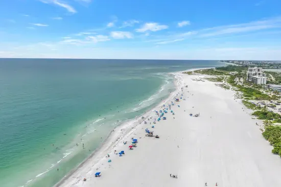Sweeping aerial views of pristine white sand and turquoise beachfront