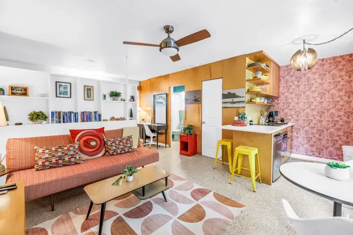Bright mid-century living area with bar seating, dining nook, and stylish decor