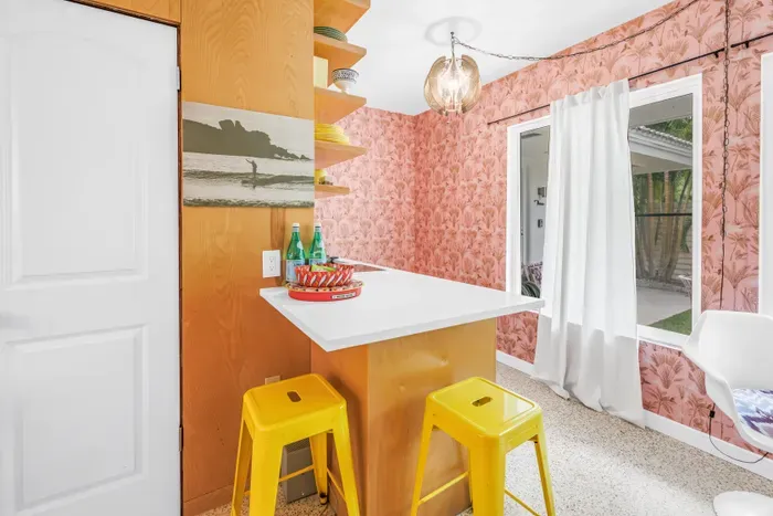 Sunny breakfast bar with bold wallpaper and cheerful seating